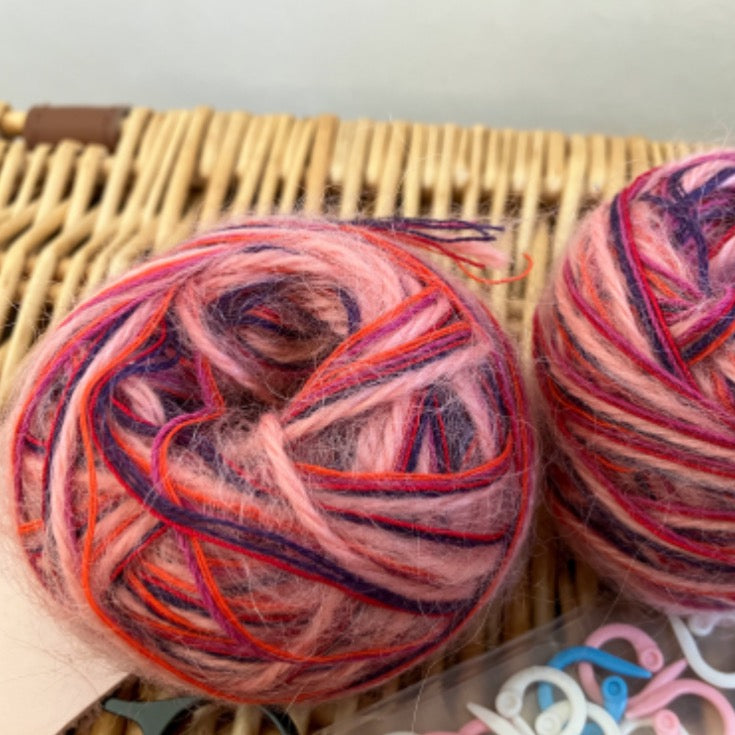 two balls of pink+purple+orange mixed fiber yarn