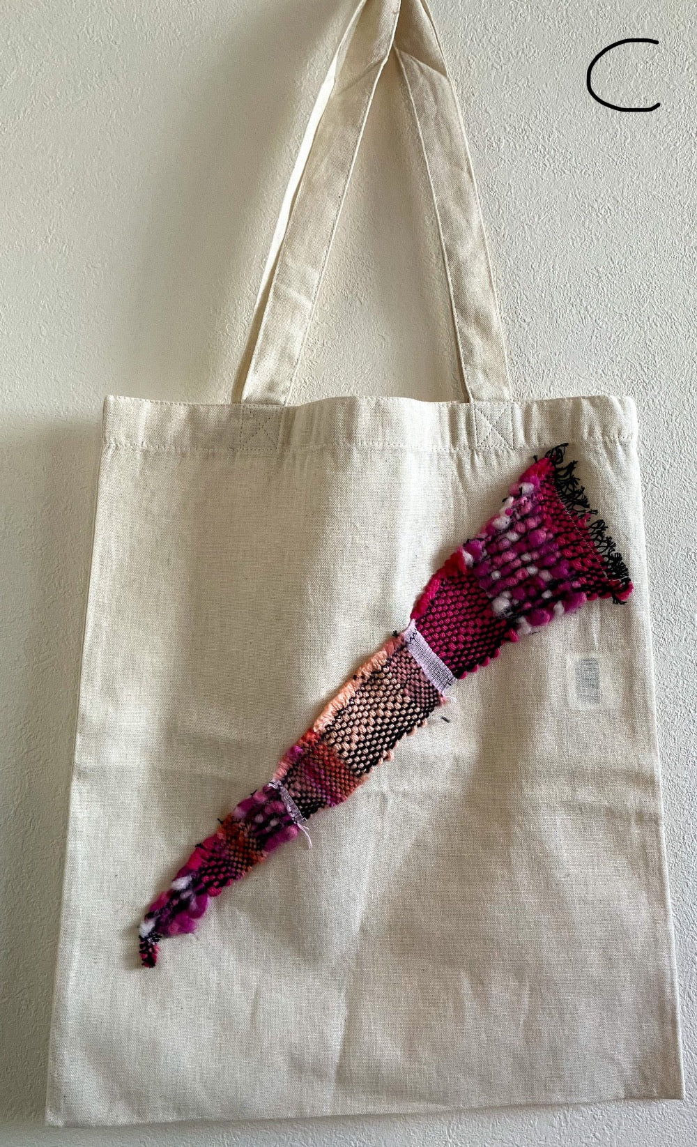 Beige cotton bag embellished with triangle of pink wool