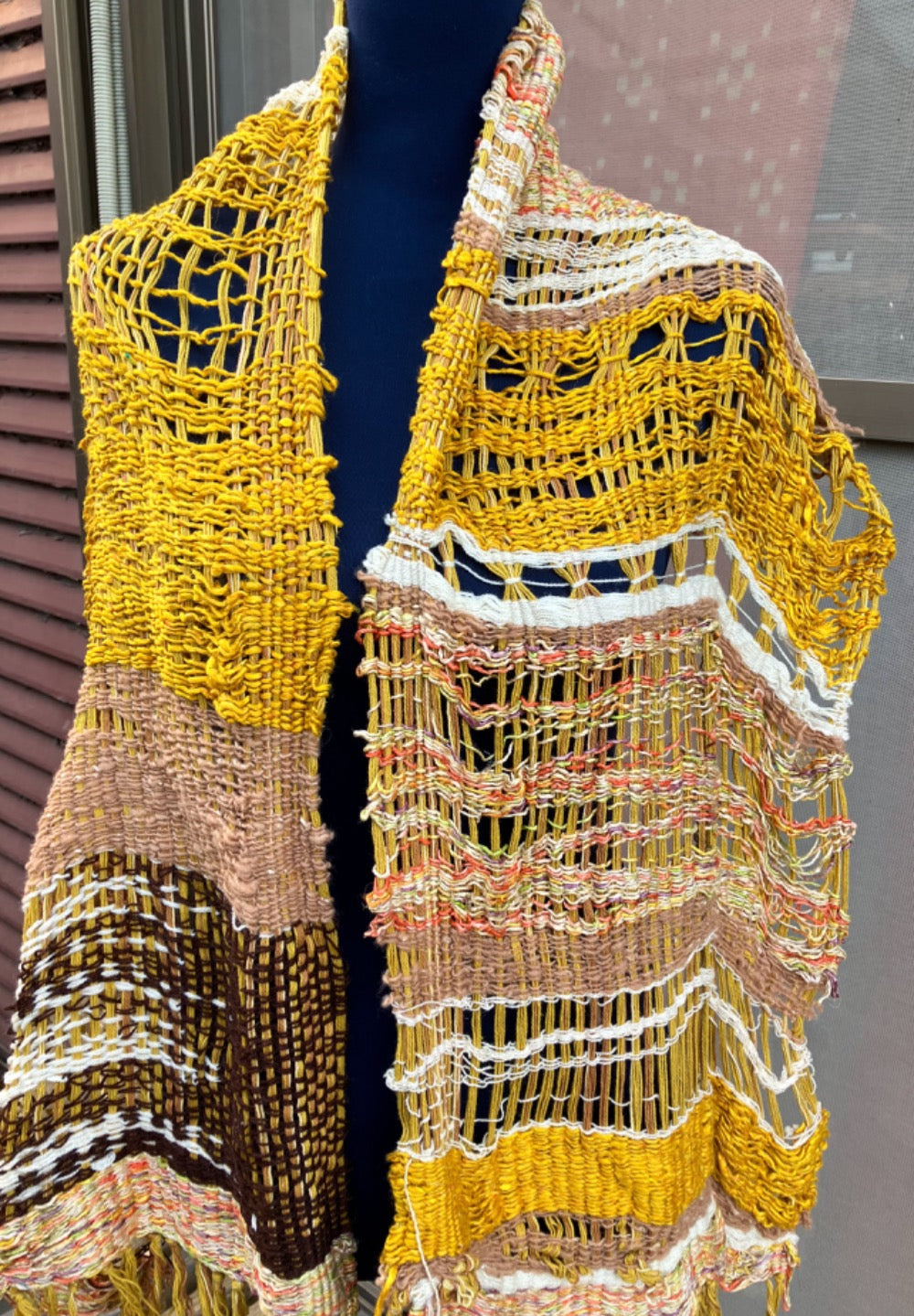 Lacey gold, brown, white, and variegated scarf on blue mannequin