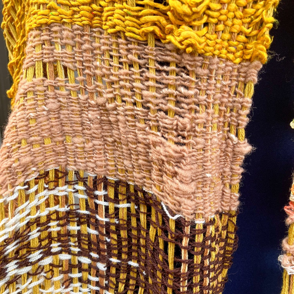 Lacey gold, brown, white, and variegated scarf on blue mannequin
