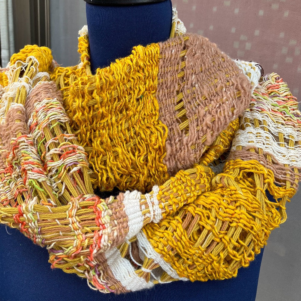Lacey gold, brown, white, and variegated scarf on blue mannequin
