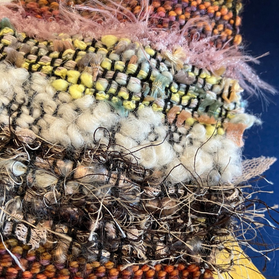 Close up of various, mixed fiber accents in brown and yellow shrug
