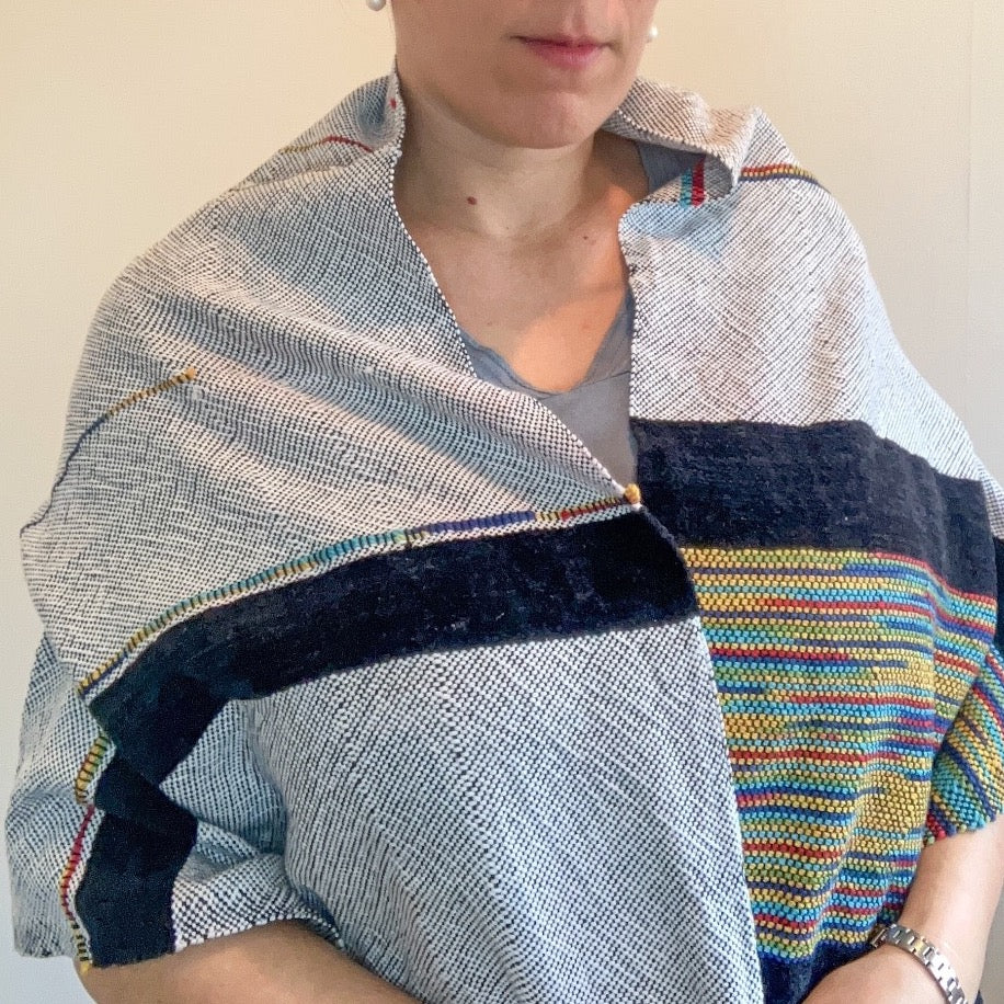 Female model wearing black and white shawl with multicolor accents and side. There are two blocks of velvety black yarn accents.
