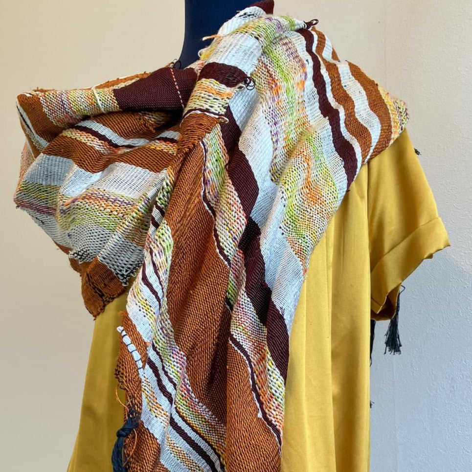 Female mannequin in gold dress wearing brown and cream silk shawl draped over shoulders