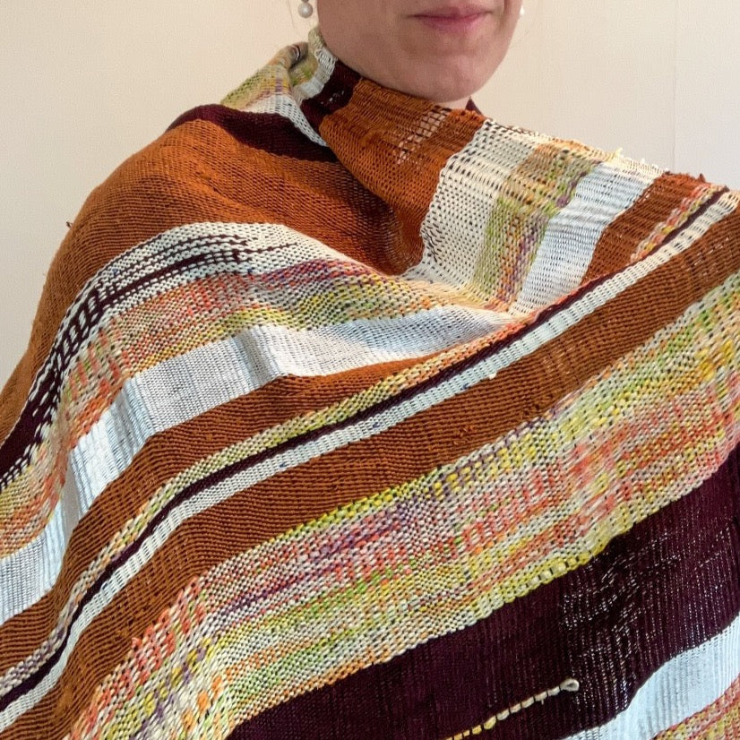 Female model holding open brown and cream shawl