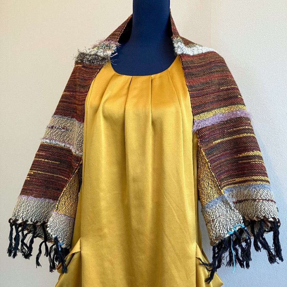 Brown and golden fringed shrug on blue mannequin