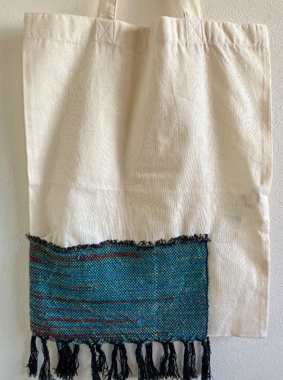 Beige cotton bag embellished with wide strip of blue-green and red cotton