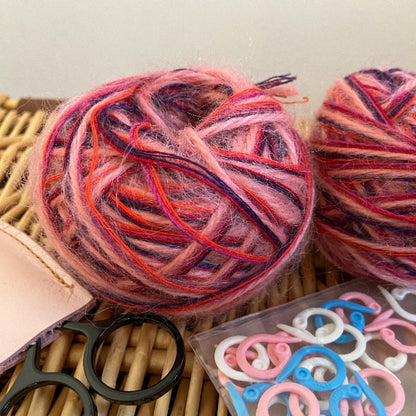 two balls of pink+purple+orange mixed fiber yarn