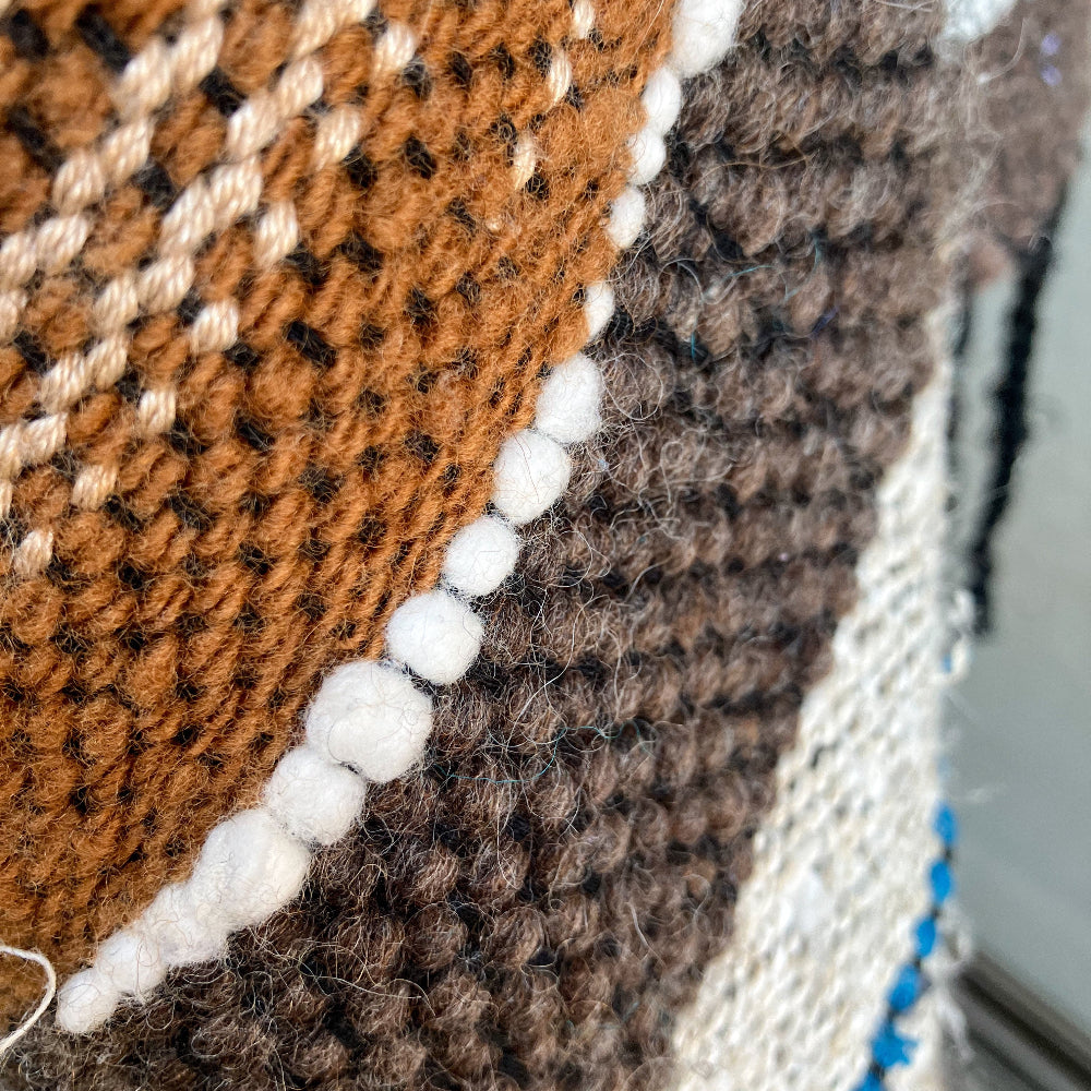 Up close detail of brown wool and white cotton inlay