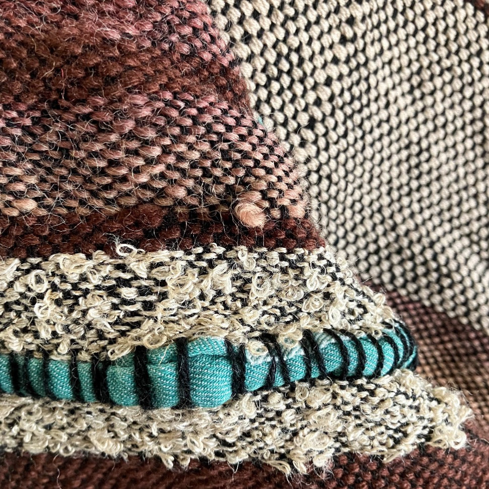 Upclose detail of brown and off-white yarns with turquoise fabric inlay