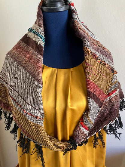 Alternative way to wear brown and earth tone shawl scarf as a cowl, on a mannequin dressed in gold
