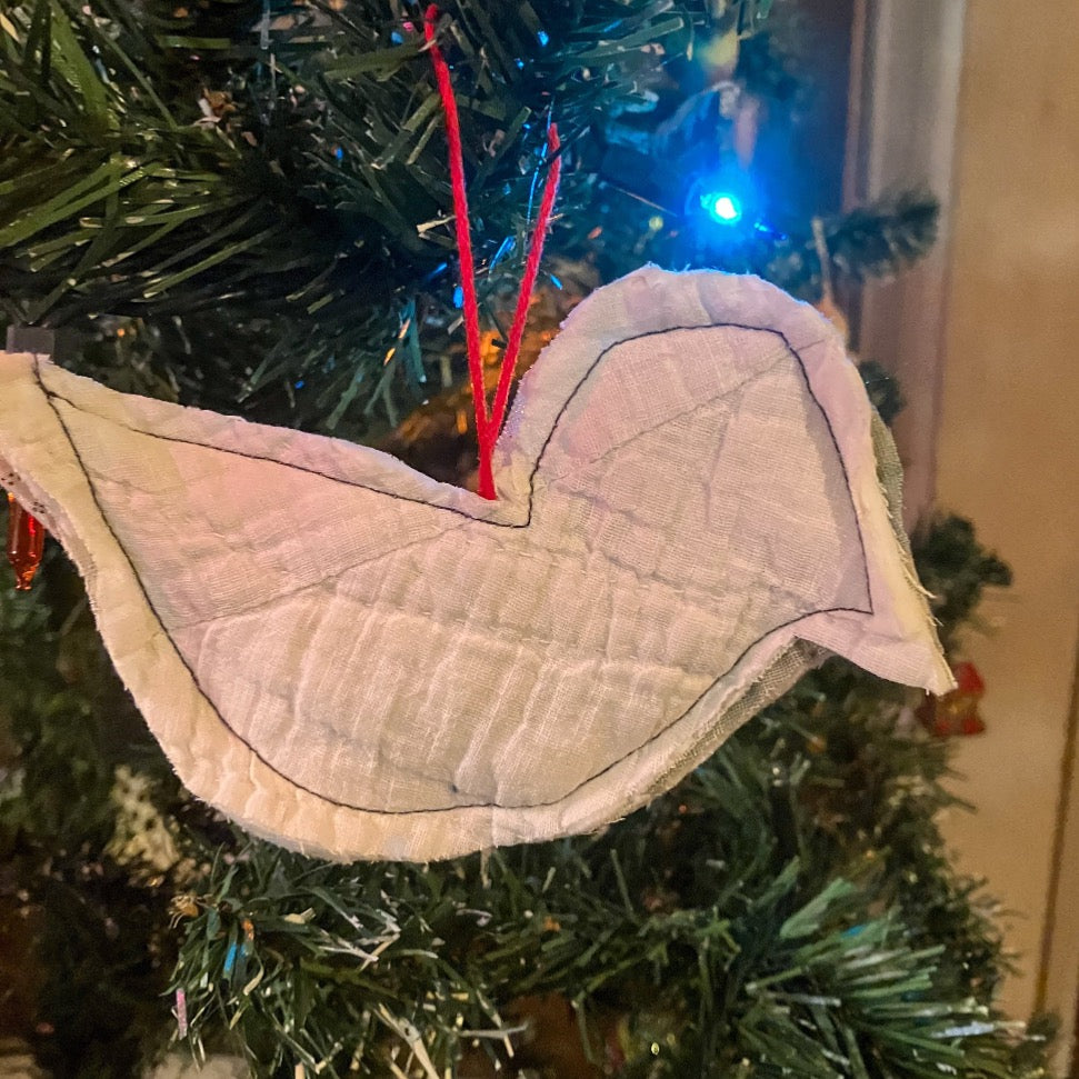Quilted bird hanging on Christmas tree with Christmas lights