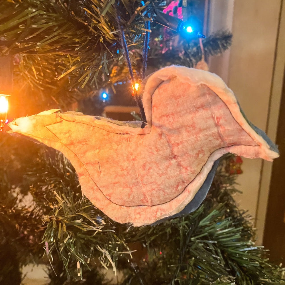 Quilted bird hanging on Christmas tree with Christmas lights