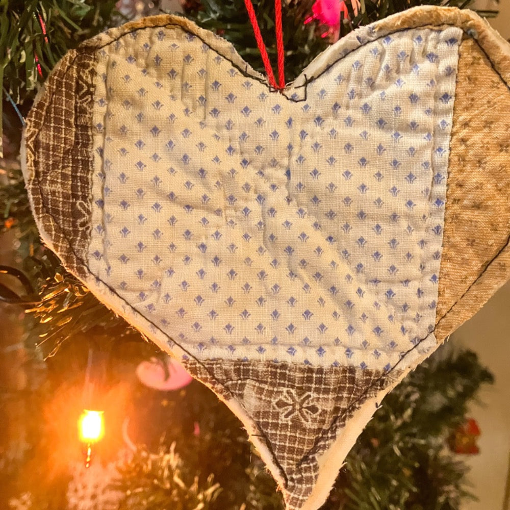 Quilted heart hanging on Christmas tree with Christmas lights