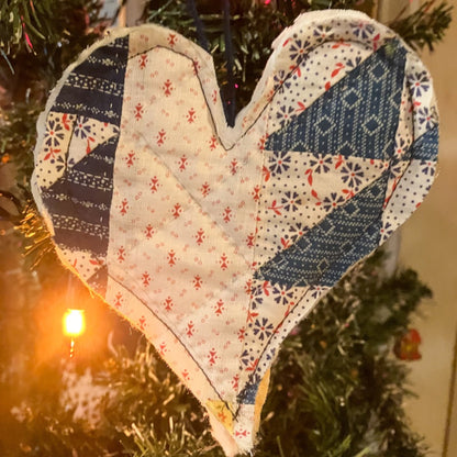 Quilted heart hanging on Christmas tree with Christmas lights
