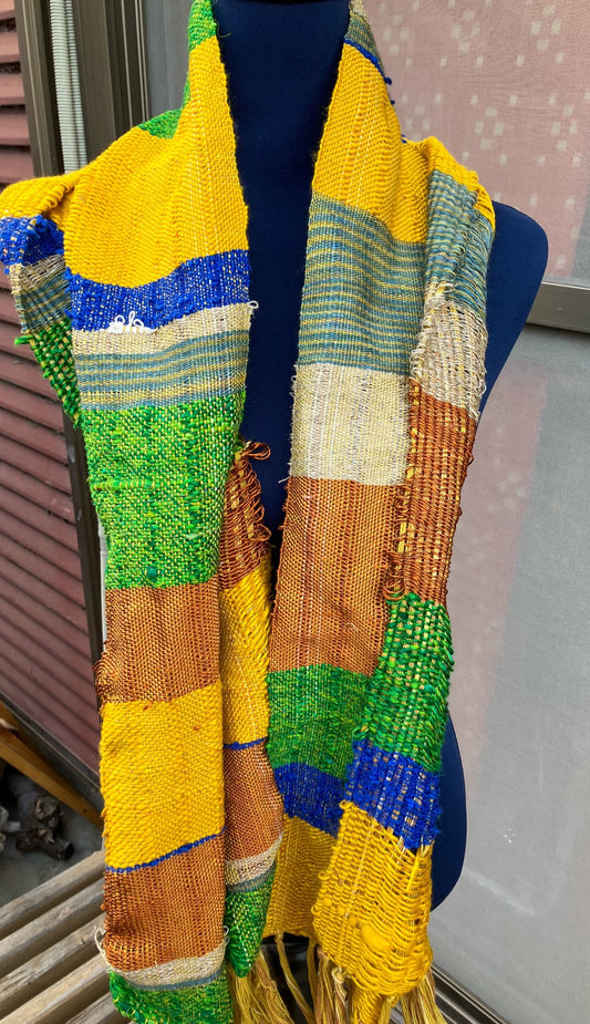 Vivid blue, yellow, copper, and green scarf on blue mannequin