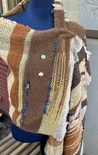 brown and cream colored shawl with blue inlays and light blue buttons