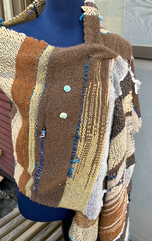 brown and cream colored shawl with blue inlays and light blue buttons