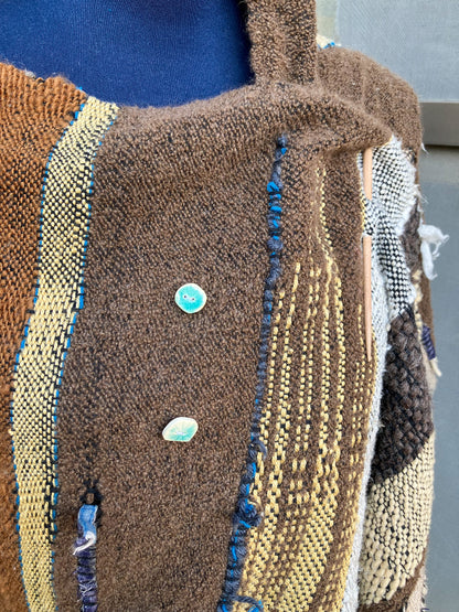 closeup of brown shawl and blue buttons