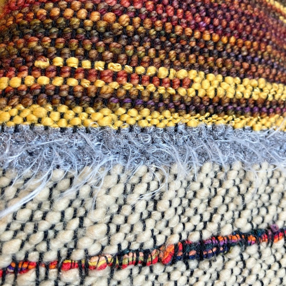 Closeup of malabrigo wool (brown) and swiss cotton (yellow) plus mixed fiber accents