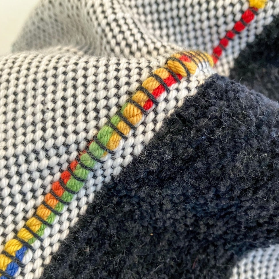 Detail of black velvety yarn and multicolor accent